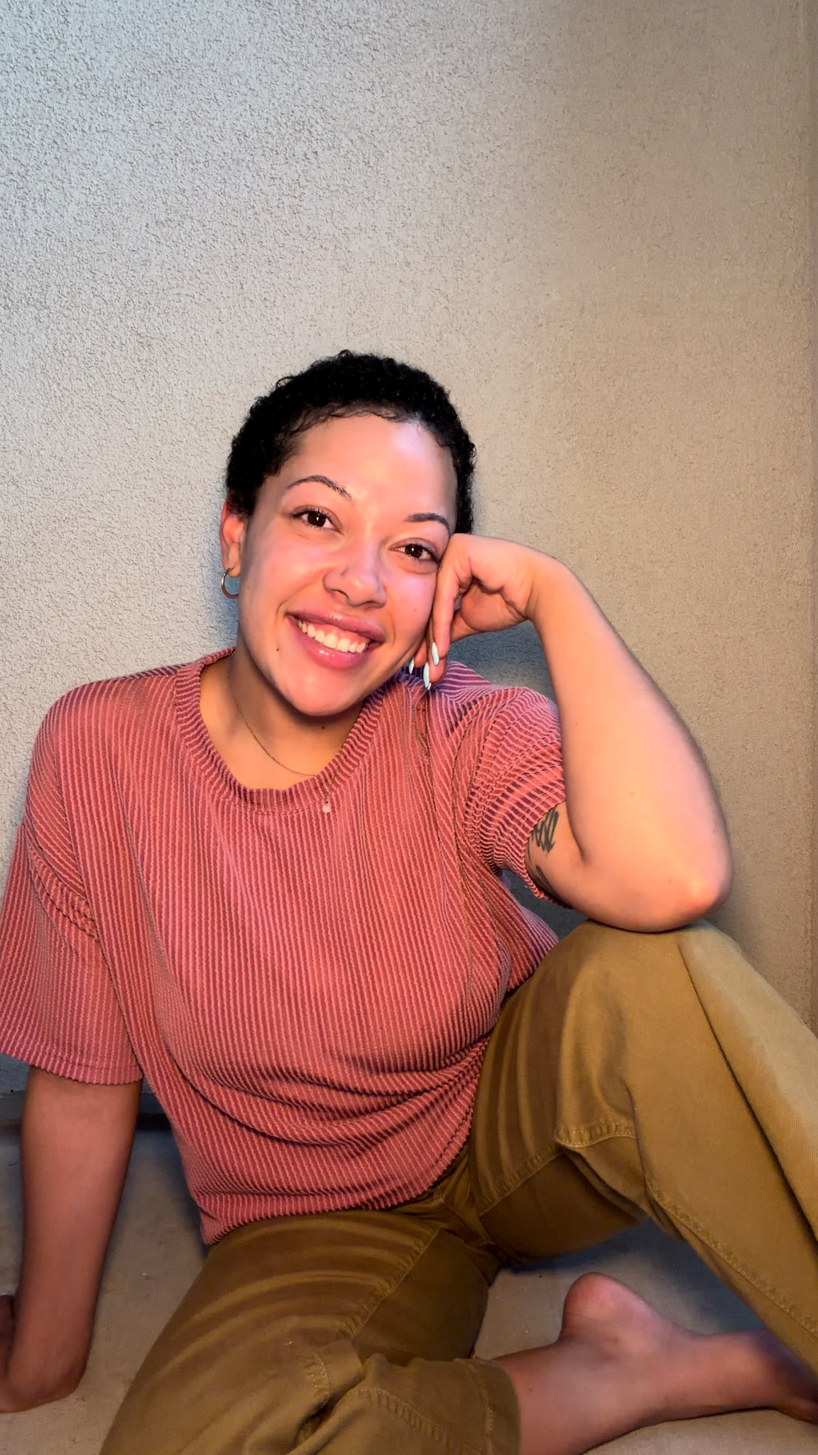 Makayla Askew, founder of Ascension Creative Co, smiling in a rose-colored shirt